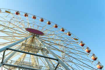 Ferris Wheel And Green Trees Against Blue Sky. Summer Amusement Park Scene With Ferris Wheel Rising...