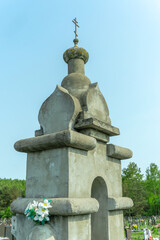 Fototapeta premium Monumental chapel cross against a tranquil blue sky. Weathered stone chapel cross standing proudly under an expansive sky a symbol of faith and enduring beauty.