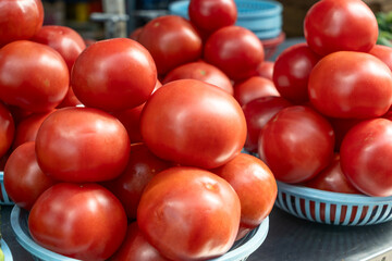 Vibrant red tomatoes symbolizing the essence of life and growth. Fresh tomatoes on display at a bustling market, inviting a taste of summer.