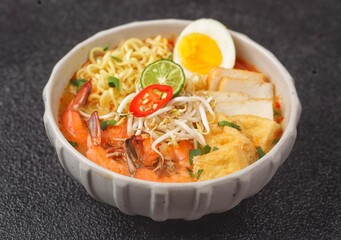 Laksa Singapore is a spicy noodle soup popular in the Peranakan cuisine of Southeast Asia. Laksa consists of thick wheat noodles or rice vermicelli with chicken, prawn or fish, served in spicy soup.