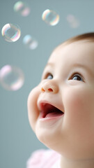 Happy baby looking at floating soap bubbles with joyful expression on blue background