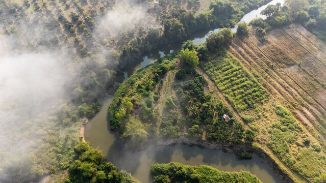Aerial view of river flowing through abundance landscape in rural area of Chiang Rai province of Thailand.