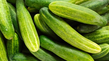 Piles of cucumbers displayed at a traditional market, the concept of healthy food and trade