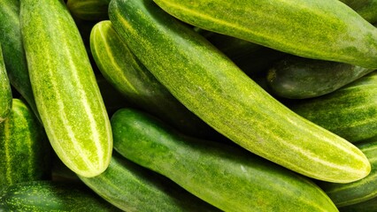 Piles of cucumbers displayed at a traditional market, the concept of healthy food and trade