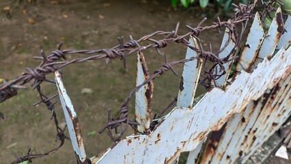 Barbed Wire and Rusty Metal Fence: A Deterrent with Character, Weathered Steel Barrier with Barbed...