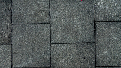 Textured surface featuring natural stone paving pattern. Geometric gray stone arrangement.