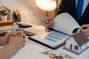 the staff is explaining information about home insurance documents to the buyers, when buying a...