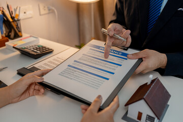 the staff is explaining information about home insurance documents to the buyers, when buying a...