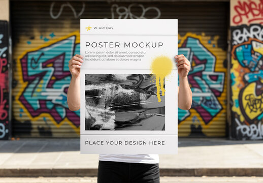 Person Holding Poster in Front of Graffiti Wall Mockup