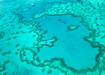 Aerial view of underwater reefs and Heart Reef of the Great Barrier Reef, the world's largest coral reef system with its clear waters, near Whitsundays Islands, Coral Sea, Australia 2020.