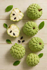 Obraz premium Annona Fruits with Juicy Pulp on Wooden Surface – AI Generated