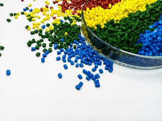 various colors of masterbatch granules in glass containers, polymer carrying resin and pigments poured in white background, suitable for product catalog design of industrial plastic company profile