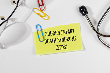 A serious medical note marked “SIDS” (Sudden Infant Death Syndrome) is placed on a doctor’s...