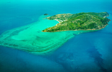 Aerial view of submerged reefs (green color) and surface clear waters (blue color) at Great Barrier...