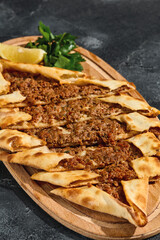 Turkish pide with beef filling, rustic natural lighting, overhead composition on wooden board