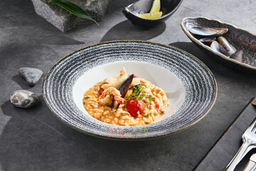 Seafood risotto in moody lighting, overhead composition with stone accents and modern plating