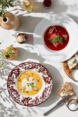 Borscht and pumpkin cream soup with shrimp, bright natural light, overhead restaurant flatlay