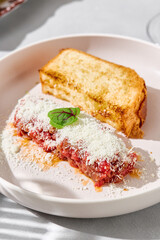 Beef tartare with grated cheese and toast, bright lighting, closeup composition