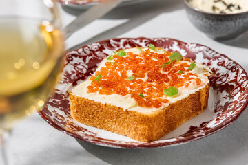 Brioche with butter and red caviar, bright natural light, overhead minimal composition