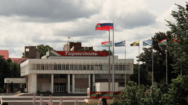 Palace of Children and Youth Creativity in Tiraspol, decorated with Transnistrian, Russian, and regional flags and coats of arms. A key educational and cultural landmark.
