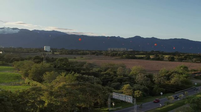 Panoramic view of RN40 highway connecting Ibagu&eacute; and Armenia, Colombia, featuring a large electricity transmission tower and surrounding landscape under clear sky.