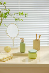 Softly lit bathroom shelf with green-themed toiletries, wooden brush, and mirror. Styled scene with...