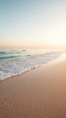 Fototapeta premium Gentle waves reaching a tranquil sandy shore under a soft pastel sky, creating a serene and peaceful coastal scene for reflection