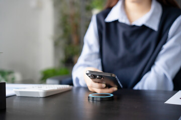 Woman charging smartphone by using magnetic wireless charger
