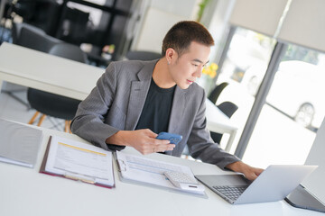 Fototapeta premium Asian Business man working with laptop. Young business man thinking Concentrated at work.