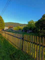A wooden fence in the middle of a grassy field