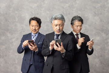 スマートフォンで検索するミドルエイジ男性ビジネスパーソン