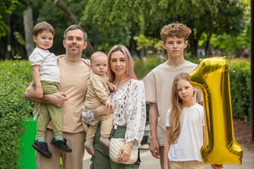 A family of five, including a woman and a baby