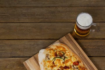 Selbstklebende Fototapeten Fresh pizza with beer glass served on wooden table © vectorfusionart