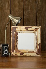 Photo frame, camera and table lamp on table