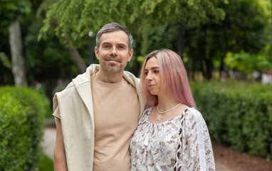 A man and a woman are standing in a park
