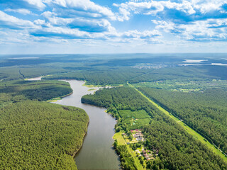Aerial view of lake or river green shore with forest. Summer season.