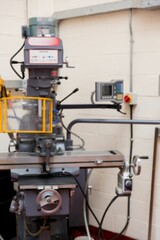 Flat design is depicting vertical milling machine with digital readout and yellow safety guard