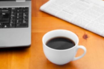 Coffee cup with newspaper on desk in office