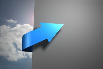 Blue arrow pointing against sky around grey wall