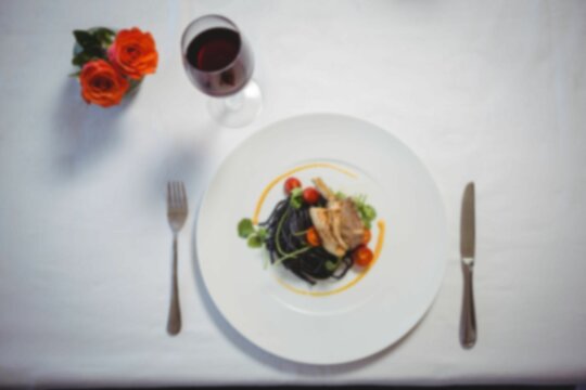 Overhead view of lamb chop in plate and wine