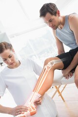 Obraz premium Woman examining injured man leg