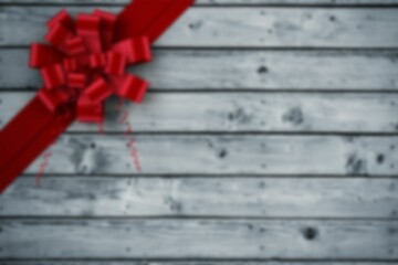 Bright red curled ribbon and bow are being shown on weathered gray wooden planks, flat design