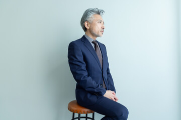 椅子に座るミドルエイジ男性ビジネスパーソン