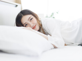 Asian young happy beautiful woman relaxes in sunlight enjoying peaceful moment smile lay down...