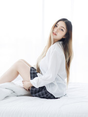 Asian young happy beautiful woman relaxes in sunlight enjoying peaceful moment sitting posing on...