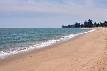 Peaceful Tropical Beach with Gentle Waves and Distant Coastline