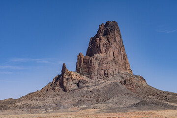 Fototapeta premium Agathlan / Agathla Peak is an eroded volcanic plug consisting of volcanic breccia / Intrusive breccia ( Ti ). south of Monument Valley, Arizona. U.S. Route 163 (U.S. Highway 163, US 163)