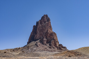 Fototapeta premium Agathlan / Agathla Peak is an eroded volcanic plug consisting of volcanic breccia / Intrusive breccia ( Ti ). south of Monument Valley, Arizona. U.S. Route 163 (U.S. Highway 163, US 163)