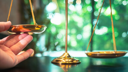 The golden scales representing justice but a hand appears to tilt the fair scales. The idea of...