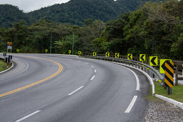 On the way up the mountain, the signaled curve warns drivers with reflective signs and vivid paint....